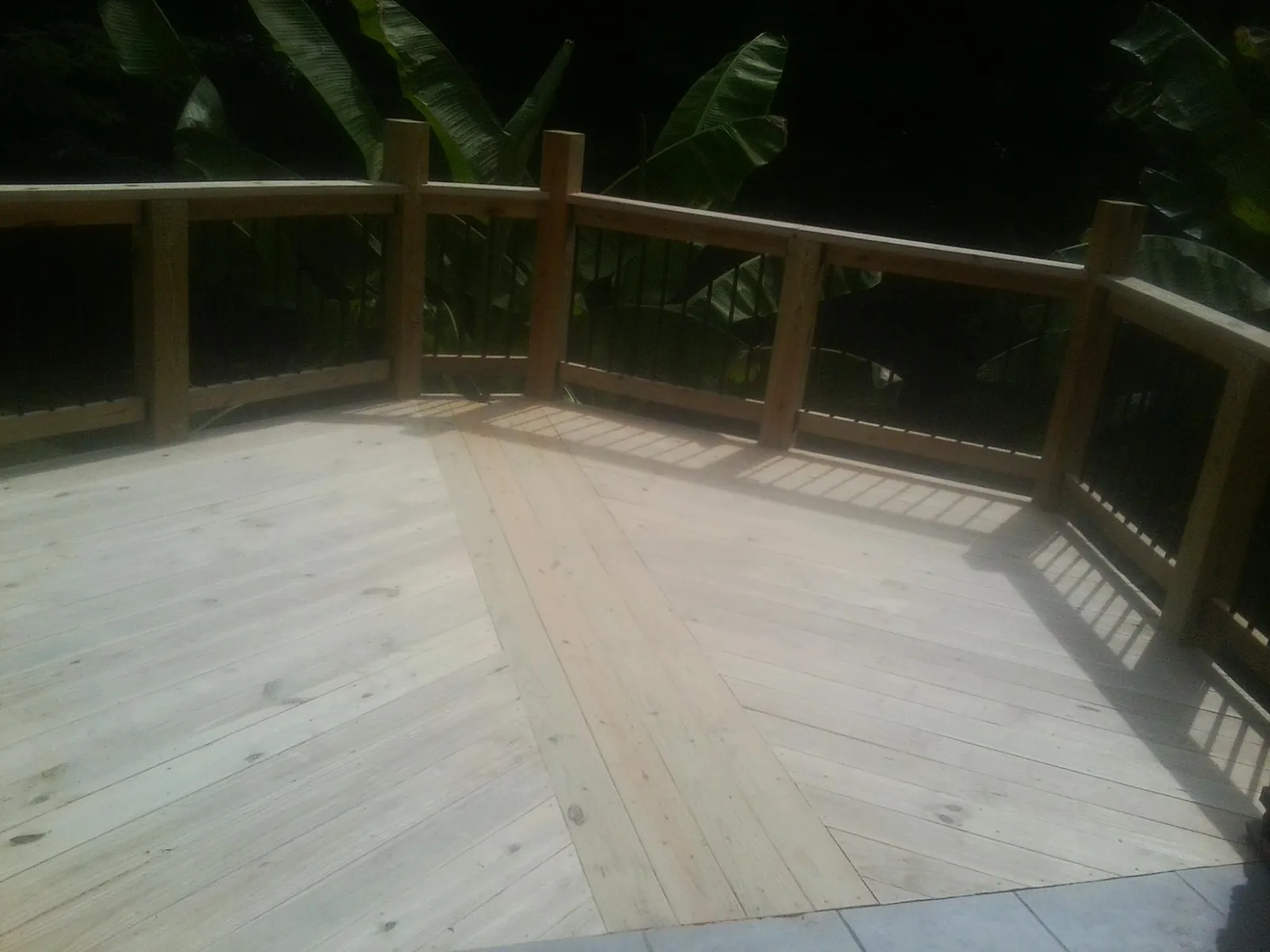 New wood deck and railing built off the back of a home in Pine